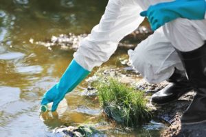 scientist pulling water samples from a stream